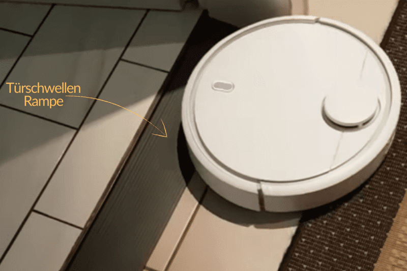 Ein Saugroboter überfährt eine Türschwelle mit Hilfe einer Türschwellenrampe